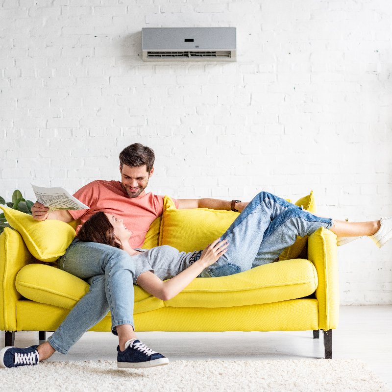 couple relaxing under an air conditioner 