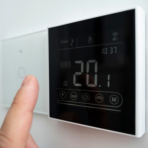 finger adjusting a thermostat