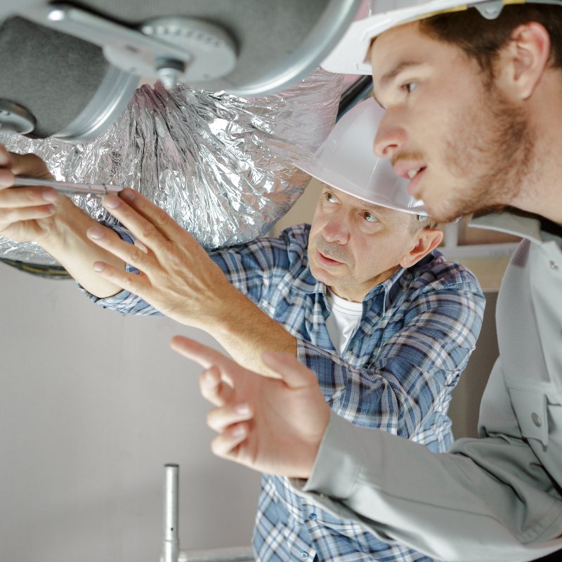 technicians repairing an air duct system